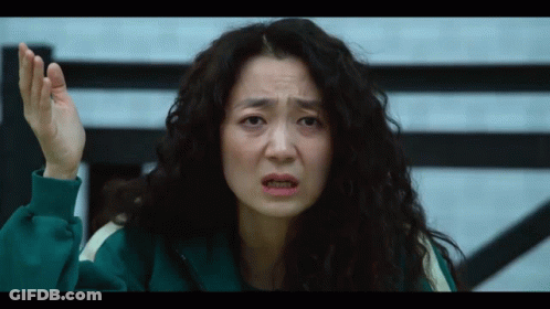 A Woman With Curly Hair Is Wearing A Green Tracksuit And Making A Funny Face GIF