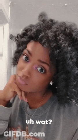 A Woman With Curly Hair Is Wearing A Grey Shirt That Says Uh Wat On It GIF