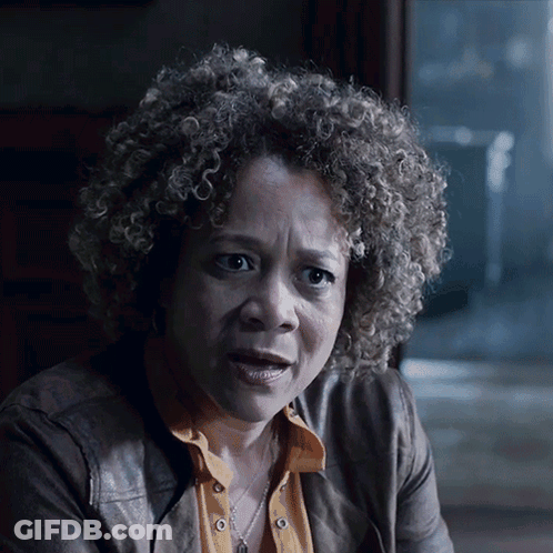 A Woman With Curly Hair Is Wearing A Leather Jacket GIF