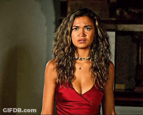 A Woman With Curly Hair Is Wearing A Red Top And A Choker . GIF
