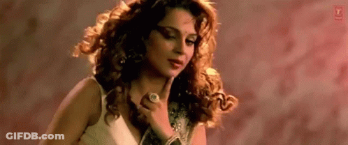 A Woman With Curly Hair Is Wearing A Ring On Her Finger . GIF