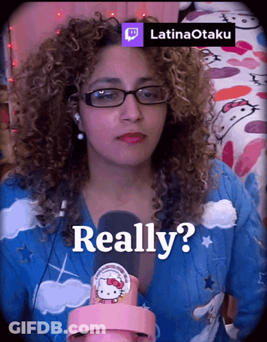 A Woman With Curly Hair Is Wearing Glasses And A Hello Kitty Shirt And Says Really GIF