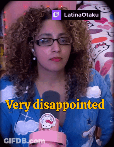 A Woman With Curly Hair Is Wearing Glasses And A Hello Kitty Sweater GIF