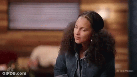 A Woman With Curly Hair Is Wearing Headphones And A Hat While Sitting In A Cabin . GIF
