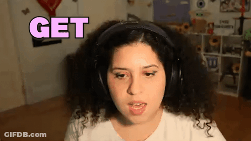 A Woman With Curly Hair Is Wearing Headphones And Says Get GIF