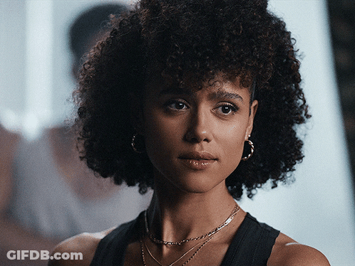 A Woman With Curly Hair Is Wearing Hoop Earrings GIF