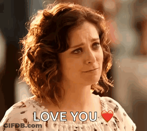 A Woman With Curly Hair Says Love You With A Red Heart GIF