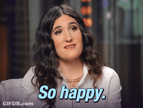 A Woman With Curly Hair Says So Happy In Blue Letters GIF