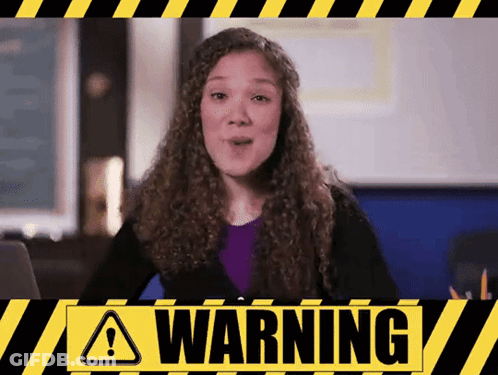 A Woman With Curly Hair Stands In Front Of A Warning Sign GIF