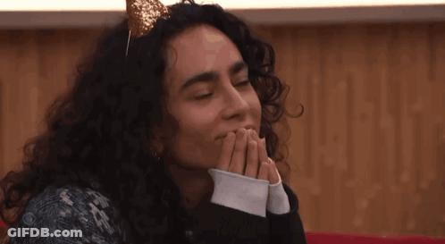 A Woman With Curly Hair Wearing A Headband With A Gold Bow On It GIF