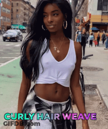 A Woman With Curly Hair Wearing A White Tank Top And Plaid Skirt GIF