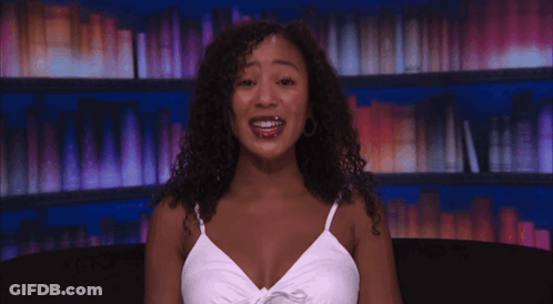 Curly-Haired Woman Smiling In White Tank Top GIF