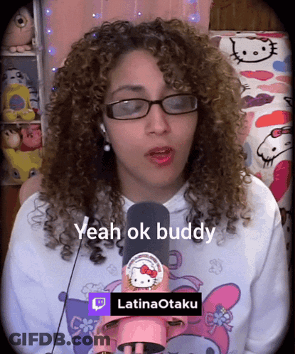 A Woman With Curly Hair Wearing Glasses And A Hello Kitty Shirt Says " Yeah Ok Buddy " GIF