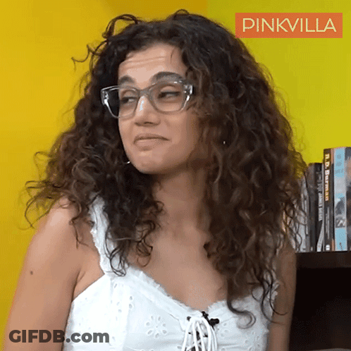 A Woman With Curly Hair Wearing Glasses And A White Tank Top With A Pinkvilla Logo In The Corner GIF