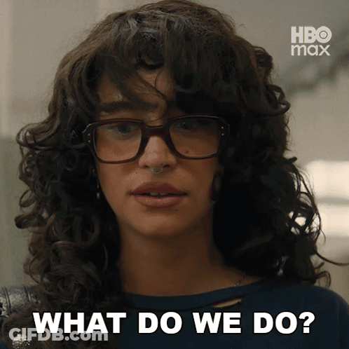 A Woman With Curly Hair Wearing Glasses Says What Do We Do GIF
