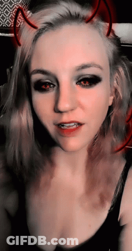 A Woman With Devil Horns On Her Head Is Taking A Selfie GIF