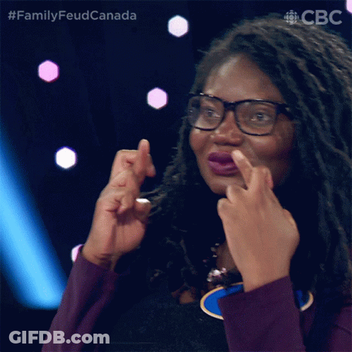 A Woman With Dreadlocks And Glasses Is Making A Face With Her Fingers GIF