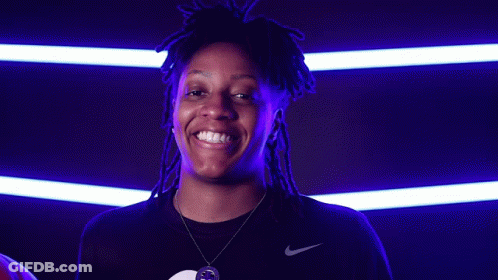 A Woman With Dreadlocks Is Holding A Basketball And Smiling For The Camera GIF