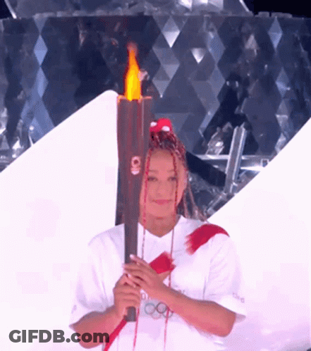 A Woman With Dreadlocks Is Holding A Torch That Says Tokyo On It GIF