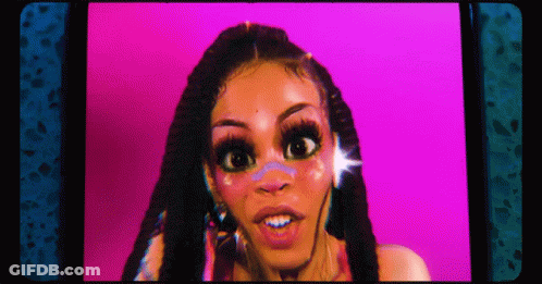 A Woman With Dreadlocks Is Looking At The Camera With A Pink Background . GIF