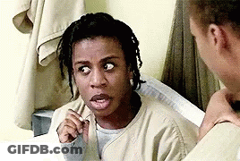A Woman With Dreadlocks Is Sitting Next To A Man In A Prison Cell And Making A Funny Face . GIF