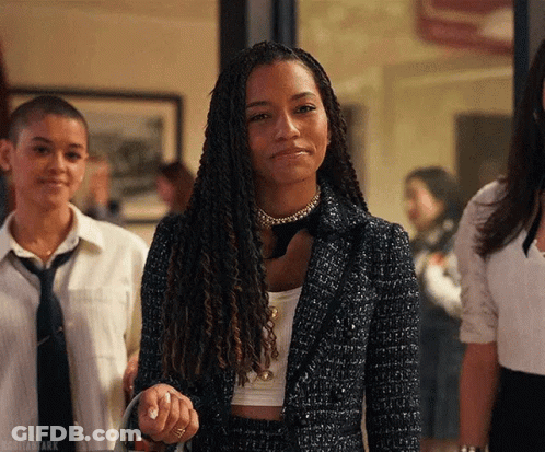 A Woman With Dreadlocks Is Standing Next To A Group Of Women In Suits And Ties . GIF