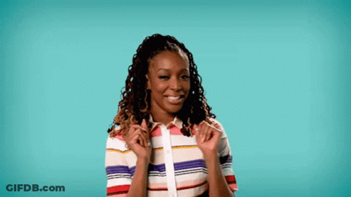 A Woman With Dreadlocks Is Wearing A Colorful Striped Shirt And Smiling With Her Hands On Her Shoulder . GIF