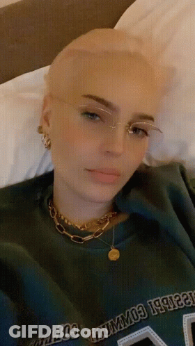 A Woman With Glasses And A Green Shirt That Says Columbia GIF