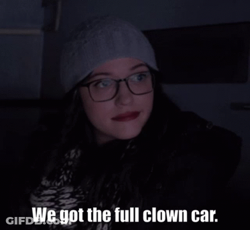 A Woman With Glasses And A Hat Says We Got The Full Clown Car GIF