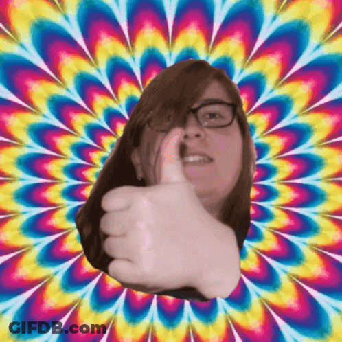 A Woman With Glasses Giving A Thumbs Up In Front Of A Colorful Background GIF