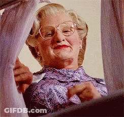 A Woman With Glasses Is Looking Out A Window GIF