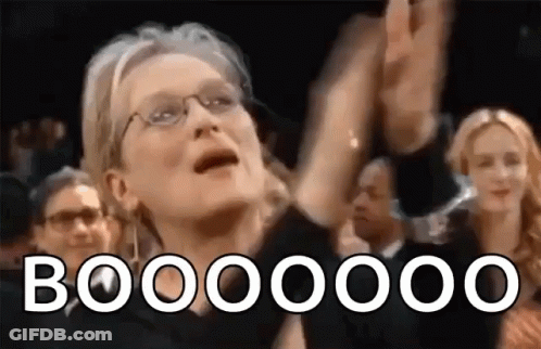 A Woman With Glasses Is Raising Her Hands In The Air While A Crowd Applauds Her . GIF