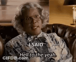 A Woman With Glasses Is Sitting On A Couch And Saying `` I Said Hell To The Yeah '' . GIF