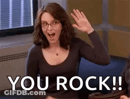 A Woman With Glasses Is Waving Her Hand And Saying `` You Rock '' . GIF
