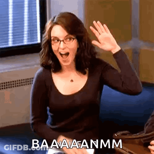 A Woman With Glasses Is Waving Her Hand And The Words Baaaaanmm Are Above Her GIF