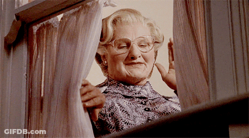 A Woman With Glasses Looks Out A Window GIF