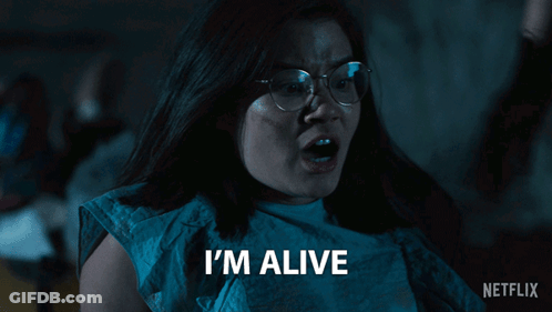A Woman With Glasses Says I 'M Alive In Front Of A Netflix Logo GIF