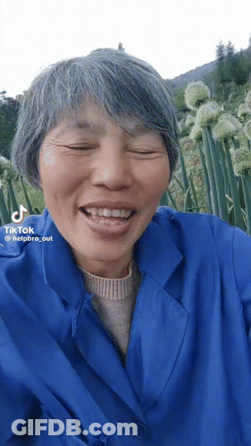 A Woman With Gray Hair And A Blue Jacket Has A Tiktok Watermark On Her Face GIF