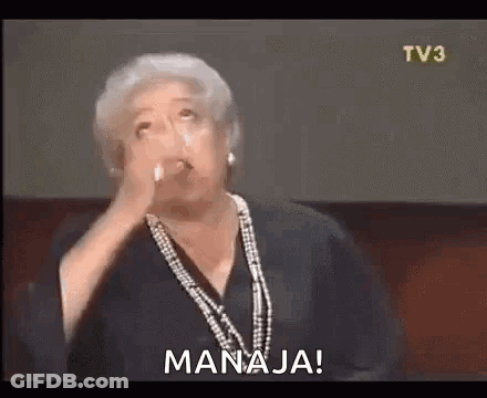 A Woman With Gray Hair Is Holding A Glass Of Water In Her Hand And Says `` Manaja '' . GIF