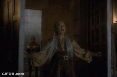 A Woman With Gray Hair Is Standing In A Dark Room GIF