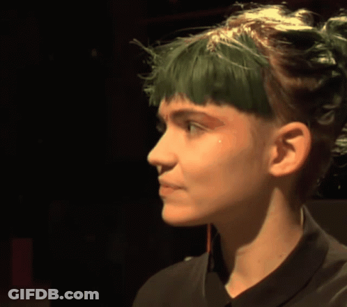 A Woman With Green Hair And A Black Shirt GIF