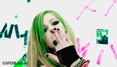 A Woman With Green Hair Is Blowing A Kiss With Her Hand GIF