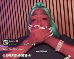 A Woman With Green Hair Is Covering Her Mouth In Front Of A Wooden Wall GIF