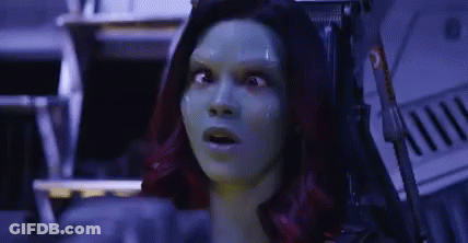 A Woman With Green Hair Is Sitting In A Chair With Her Mouth Open And A Surprised Look On Her Face . GIF