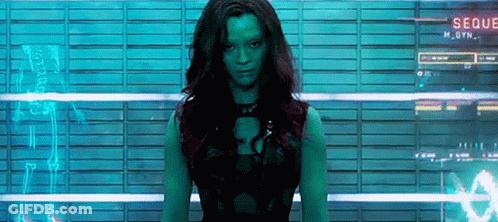A Woman With Green Hair Is Standing In Front Of A Wall With A Sign That Says Seque GIF