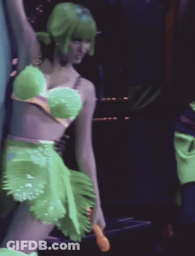 A Woman With Green Hair Is Wearing A Green Dress GIF