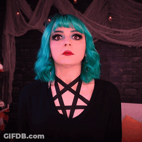 A Woman With Green Hair Is Wearing A Pentagram On Her Neck GIF