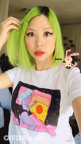 A Woman With Green Hair Is Wearing A T-Shirt With A Picture Of A Woman And A Pizza On It GIF