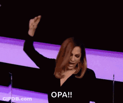 A Woman With Her Arms In The Air And The Word Opa Written On The Bottom GIF