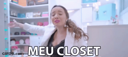 A Woman With Her Arms Outstretched In Front Of A Closet That Says Meu Closet On It GIF